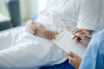 Patient on an inpatient hospital bed with a doctor examining and asking for information about the...