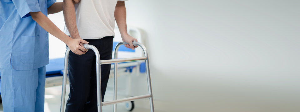 The patient is doing physiotherapy with a specialist physiotherapist, the patient is practicing walking using a walking brace with the help of a physiotherapist. Physiotherapy concepts from experts.