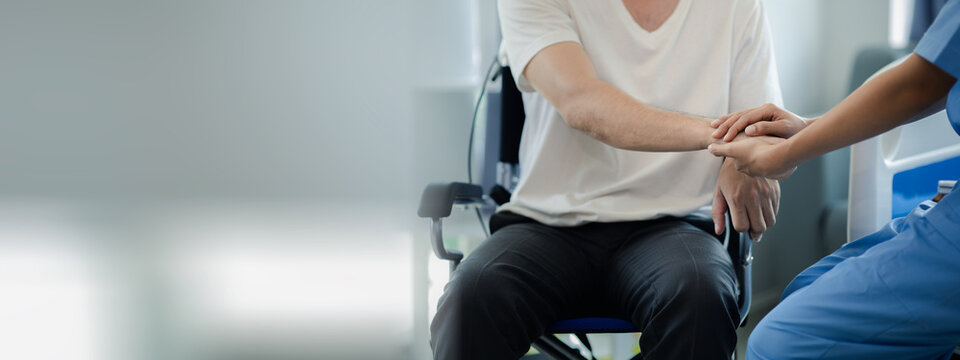 Male patient sitting in wheelchair undergoing a medical examination with specialist physician, treating injuries Getting medical treatment from specialist doctor can get the right and proper treatment