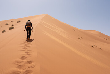 Fototapeta na wymiar Hiking up the Great Dune of Merzouga in the Erg Chebbi desert