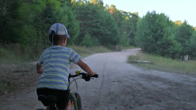 The boy riding his bike in the forest. 4k video footage 