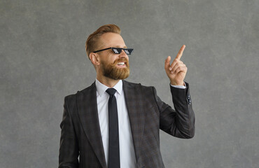 Portrait of a successful cool businessman in funny pixel glasses on a gray background. Creative man...
