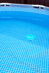 natural light. frame pool. a container with solid tablets floats in the pool for disinfection.