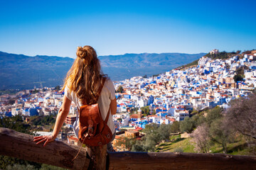 Woman enjoying beautiful panoramic view of the blue city of Chefchaouen in the Rif mountains,...