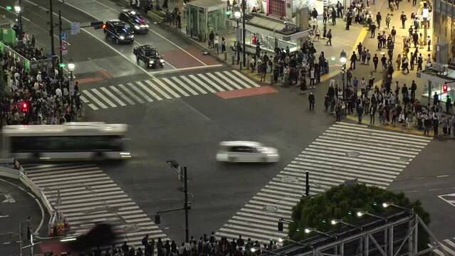 SHIBUYA, TOKYO, JAPAN : Aerial time lapse view of Shibuya crossing at night. Crowd of people walking at the crossing in busy rush hour. Japanese people and urban city nightlife concept 4K video.