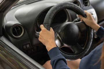 Driver's hands on a car steering wheel, close-up. Woman driving a car