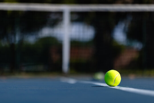 Close up of tennis ball on tennis court by net, selective focus, copy space