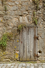 weathered wooden door in an old historic wall, Rothenburg ob der Tauber, Bavaria, Germany