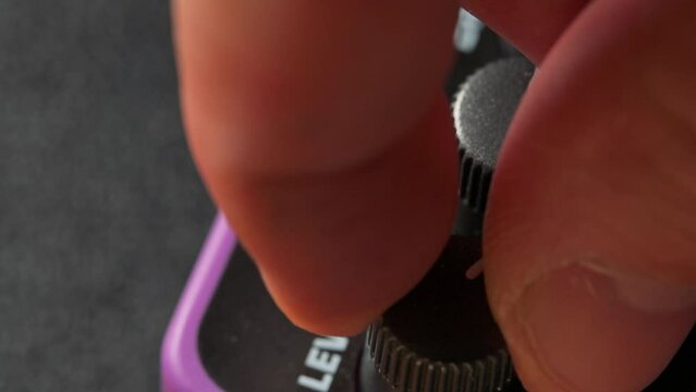 Man tuning knobs on guitar pedal effect. 4k video footage UHD 3840x2160