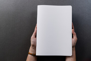 Hands of caucasian womanholding book with copy space on grey background