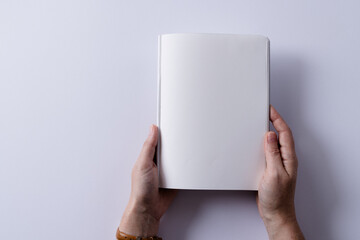 Hands of caucasian woman holding book with copy space on white background