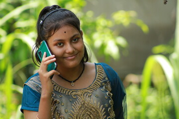 Beautiful Young Girl Using Smartphone outdoors.
