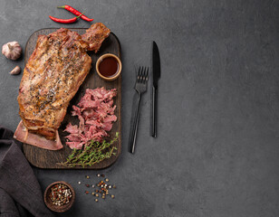 BBQ lamb shoulder cooked in a smoker with torn meat, spices and sauce on a wooden board. The...
