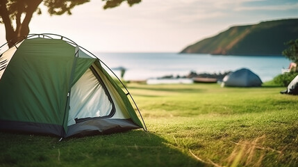 Selective focused on Lawn or green grass ground of camping ground near the sea beach. with camping tent in the background