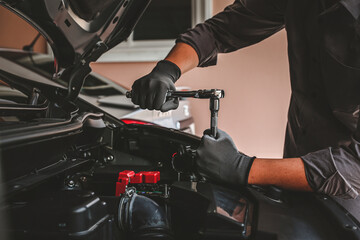 Close-up hand auto mechanic using the wrench to repairing car engine problem. Concepts of check and fix car and maintenance servicing.