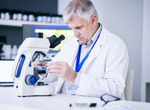 Mature scientist, man and microscope, review and analysis for science study, medical research and biotechnology in lab. Male person, doctor and pathology, check test sample with scientific experiment