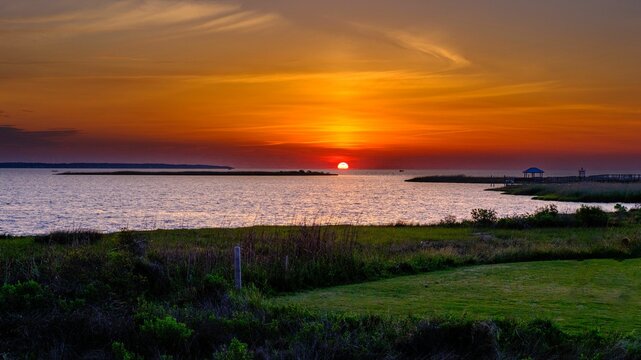 Magnificent sunset illuminates the sky over the water in Nags Head, Outerbanks