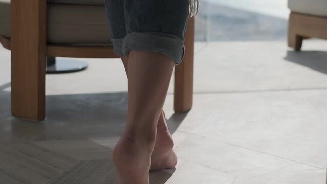 Young slender woman in black bra and unbuttoned jeans walking in a hotel room