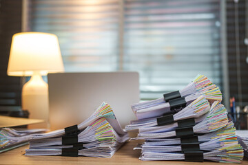 Piles of white papers Stacks of office working paper documents files with black clip on the desk in the office .