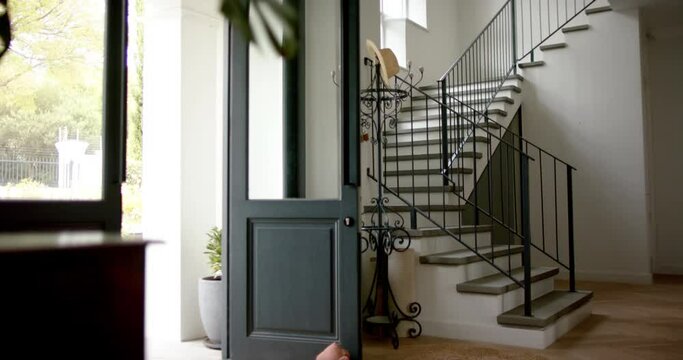 General view of staircase at home with open front door, slow motion