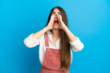 Young caucasian woman isolated on blue background shouting and announcing something