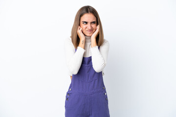 Fototapeta premium Young caucasian woman isolated on white background frustrated and covering ears