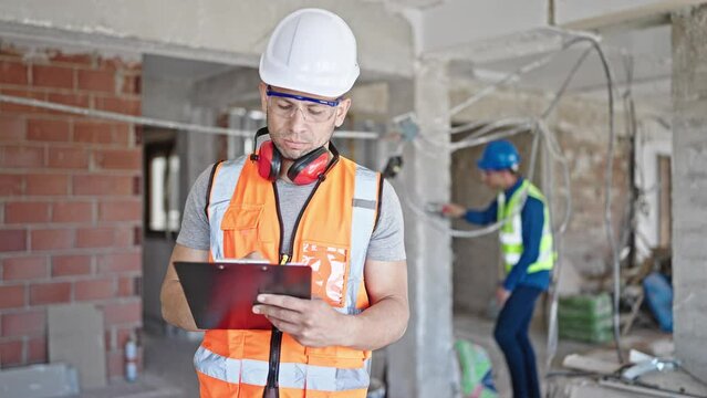 Two men builders writing document working at construction site