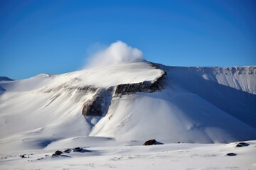 dormant volcano with snow-covered summit and steam rising from the caldera, created with generative ai