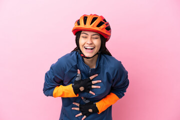 Teenager cyclist girl isolated on pink background smiling a lot - obrazy, fototapety, plakaty