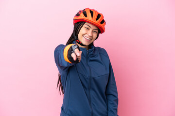 Teenager cyclist girl isolated on pink background pointing front with happy expression - obrazy, fototapety, plakaty