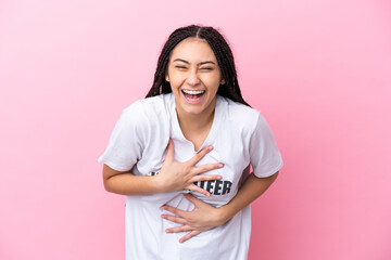 Teenager volunteer girl with braids isolated on pink background smiling a lot