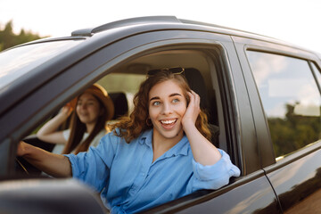 Two Young woman is resting and enjoying the trip in the car Automobile journey, traveling,...