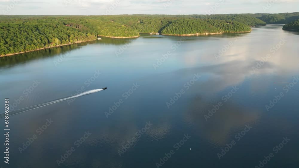 Wall mural Beautiful acene of a reflecting lake with green vegetation trees forest with gray sky