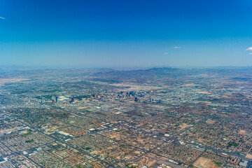 aerial landscape view of greater Las Vegas area and suburbs with famous buildings along the Las Vegas Blvd (Las Vegas Strip) and main "Harry Reid International Airport" and mountains in background