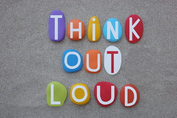 Think out of loud, creative motivational slogan composed with multi colored stone letters over...
