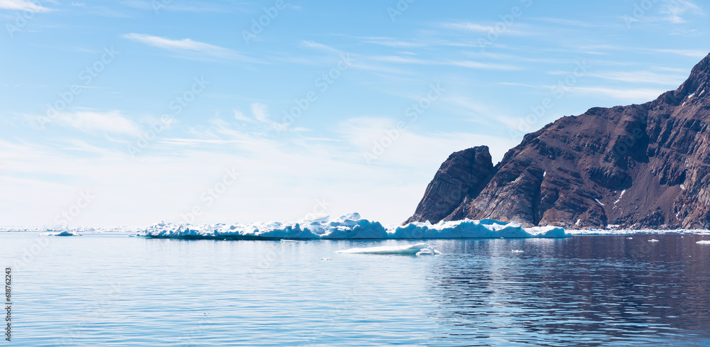 Wall mural arctic landscape of greenland in summer. beautiful view of mountains with snowy peaks and iceberg