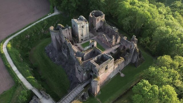 Rotatinf drone shot over Goodrich Castle with trees in village of Goodrich in Herefordshire, England