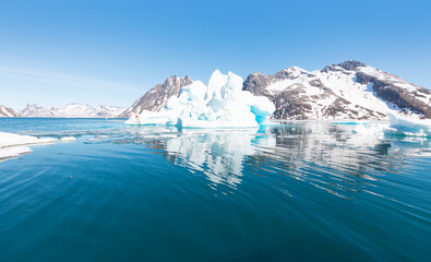 Arctic landscape of Greenland in Summer. Beautiful view of mountains with Snowy peaks and iceberg