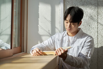 Naklejka premium Picture of a young man who is a college student standing against a wall in a lecture hall at a university in South Korea. The room is bright