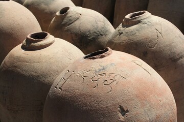 Array of pisco jugs illuminated by the warm sunlight.