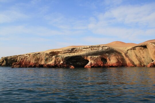 Majestic rock formation by a serene beach in Paracas National Reserve, Peru.