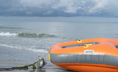 Closeup shot of orange colored plastic boat at the shore of port dickson beach, negeri sembilan,...