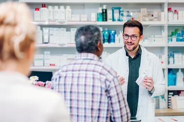Portrait of a male pharmacist working at the counter in pharmacy