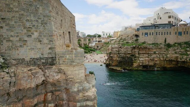 Landscape view of Lama Monachile houses on rocky mountains by the sea in Polignano a Mare, Italy