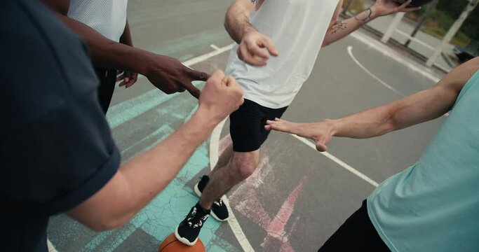 Close-up shot of basketball players playing Rock-Paper-Scissors to determine the team that will play the ball first