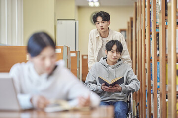 Asian Korean university library desk chair woman sitting on laptop and reading book and man helping...