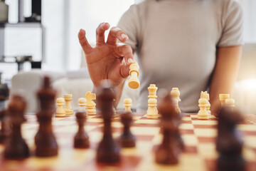Chess, game and woman with board moving piece for strategy, thinking and challenge in home....