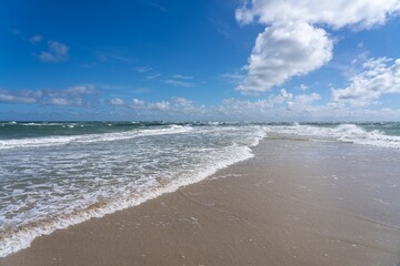 Pristine beach with white sand and azure blue ocean water in the background in Denmark.