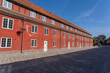 Exterior view of a traditional red-brick building with a red roof in Copenhagen, Denmark.