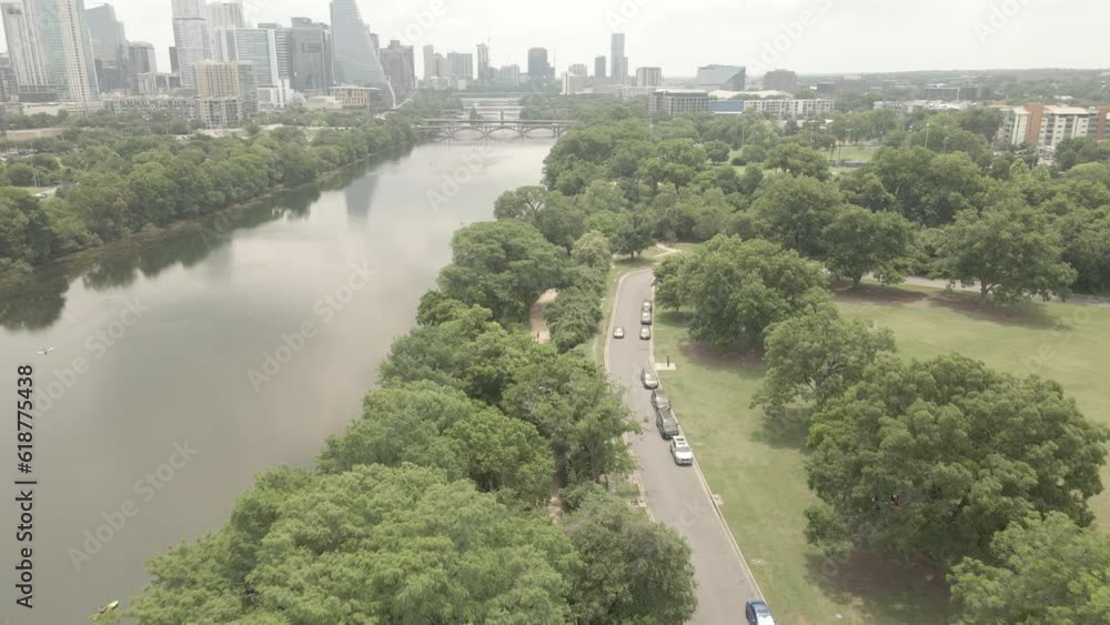 Sticker Drone footage over Zilker Park with river and trees and downtown buildings in Austin, Texas, USA